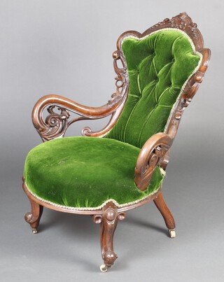 A Victorian carved mahogany show frame armchair, the seat and back upholstered in green material, raised on cabriole supports 89cm h x 69cm w x 51cm d (seat 29cm x 30cm) 