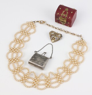 A yellow gold testing as 14ct Art Nouveau enamelled and seed pearl brooch, a novelty stamp holder in the form of a purse, a ring box and an imitation pearl necklace 