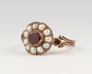 A Victorian yellow gold, testing as 9ct, garnet and seed pearl cluster ring, size L, 2.4 grams 