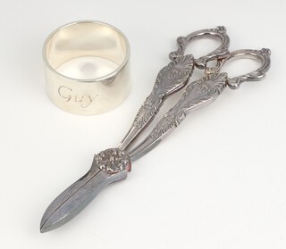 A 925 standard napkin ring 68grams (engraved Guy) together with a pair of silver plated grape scissors 