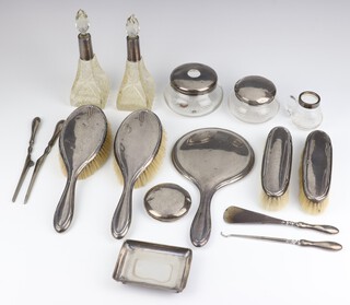 A matched silver dressing table set comprising 2 hair brushes, 2 clothes brushes, a hand mirror, 2 mounted jars, a lid, a mounted bottle, 2 mounted scents, 4 implements and a dish, mixed dates, weighable silver 96 grams 