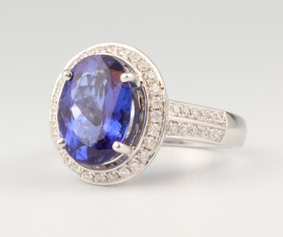 A 14ct white gold oval tanzanite and diamond cluster ring, the centre stone 4.2ct, the brilliant cut diamonds 0.54ct, size N 