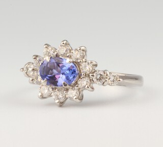 A platinum, oval tanzanite and diamond cluster ring, the centre stone 0.87ct, the diamonds 0.20ct, size N. 6.7 grams 