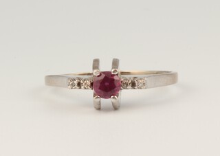 A 9ct white gold ruby and diamond ring, the centre oval cut stone 0.25ct, 4 brilliant cut diamonds 0.04ct, size T, 3.1 grams 