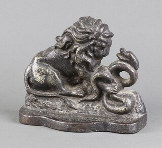 A Victorian cast iron door stop in the form of a lion encountering a snake 15cm h x 19cm w x 8cm d 