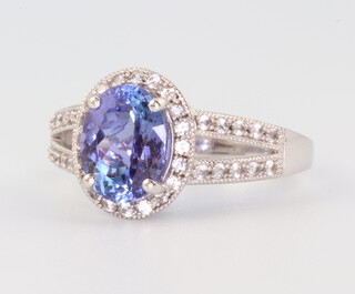 A 10ct white gold oval tanzanite and diamond ring, the centre stone 1.4ct, the brilliant cut diamonds 0.2ct, size M 1/2, 3.6 grams