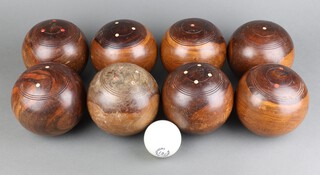 Eight 19th Century turned lignum vitae bowling woods inlaid with bone, together with a Slazenger Jack, 3 rubber bowl marks, all contained in a wooden box 