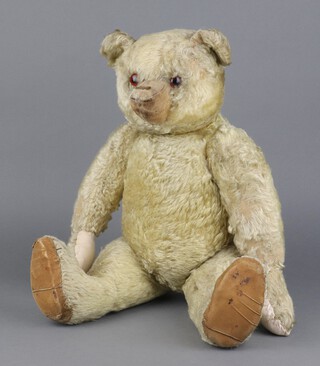 Steiff, an early 20th Century teddy bear in shaggy mohair, elongated arms, humped back, rounded ears, disc jointed limbs, brown glass eyes with black pupils (not painted), shaved snout, legs and head stuffed wood wool, torso and arms lightly kapok, 1186 grams, 50cm long 