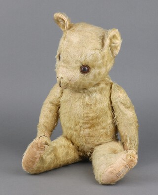 Deans Rag Book Co Ltd., a mid 1950's teddybear with plastic eyes and either cotton waste or kapok stuffing, label to foot pad 44cm 