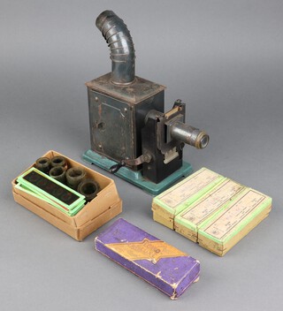 A circa 1910 tin plate candle powered magic lantern 25cm h x 10cm w x 21cm d,  together with 3 boxes of slides (cartoon scenes of landscapes, figures etc)  and a box of loose slides and 5 rolls of film 