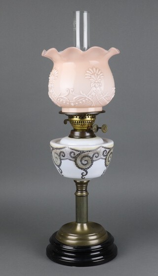 A Victorian opaque glass oil lamp reservoir with transfer decoration and opaque glass shade and chimney, raised on a gilt reeded column 60cm h 