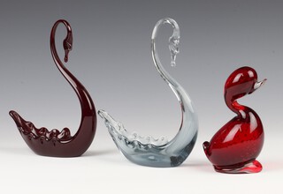 A Whitefriars red glass figure of a swan 19cm, a blue ditto 20cm and a ruby red "Dilly Duck" 14cm 