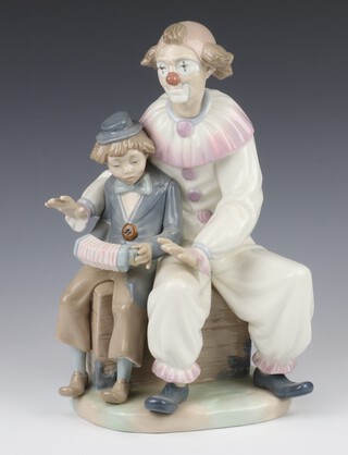 A Nao group of a clown sitting next to a boy playing a concertina 30cm 