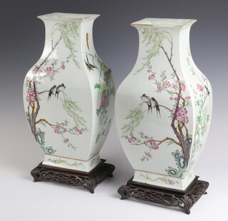 A pair of early 20th Century Chinese rectangular, baluster vases decorated with birds amongst trees and flowers 43cm, on hardwood stands 