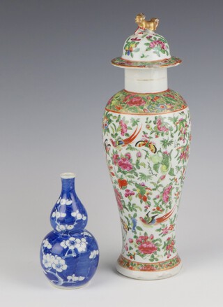 A 20th Century Chinese oviform vase and cover decorated with insects and birds amongst flowers with lion finial 36cm (the lid is chipped and stuck, the vase is cracked and chipped) and a prunus gourd vase (chipped) 15cm