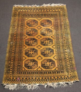 A tan and black ground Afghan rug with 10 octagons to the centre 