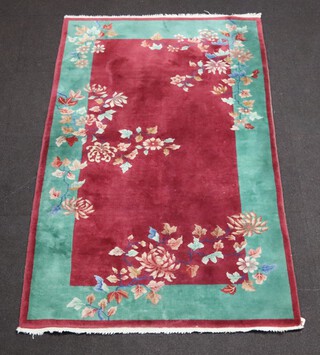 A 1930's plum and green ground Chinese rug with floral decoration 202cm x 120cm 