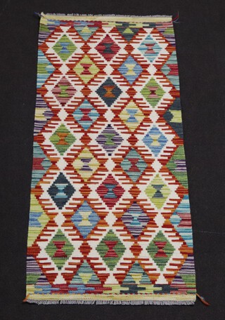 A white, tan and turquoise ground Chobi Kilim runner with overall diamond design 143cm x 62cm 