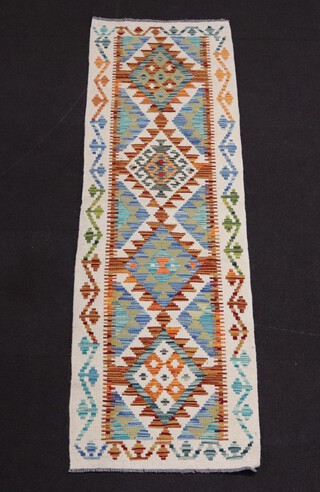 A white, green and turquoise Chobi Kilim runner with 4 diamonds to the centre 199cm x 60cm 