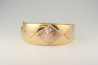 A  three colour gold, testing as 14ct, bangle, 28.3 grams