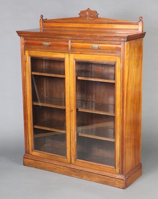 A Victorian carved mahogany bookcase with raised back fitted 2 long drawers above cupboard, the base fitted adjustable shelves enclosed by glazed bevelled panelled doors, raised on a platform base  161cm h x 120cm w x 40cm d 