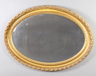 A 1920's oval bevelled plate wall mirror contained in a decorative gilt plaster frame 67cm h x 89cm w 