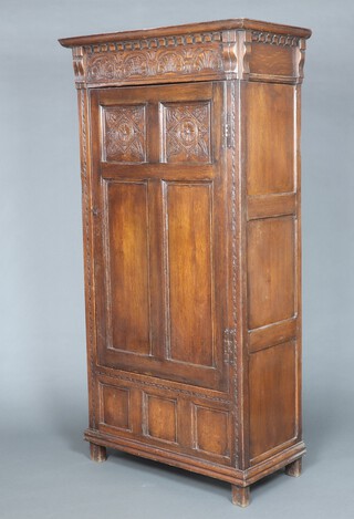 A 17th Century style carved oak hall wardrobe, fitted a shelf and enclosed by a panelled door, raised on square supports 197cm h x 102cm w x 50cm d 