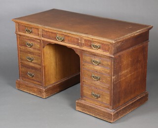 Shoolbred, an Edwardian oak desk/dressing table with inset rexine writing surface above 1 long and 8 short drawers, 75cm h x 122cm w x 60cm d 