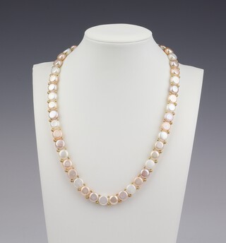 A string of cultured pearls, the flattened pearls 10mm each, with a 14ct yellow gold clasp, 45cm 