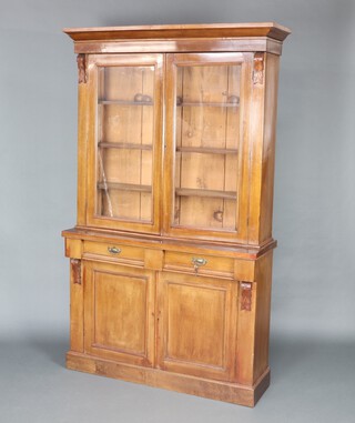 A Victorian mahogany bookcase on cabinet with moulded cornice, fitted adjustable shelves enclosed by glazed panelled doors, the base fitted 2 drawers above a double cupboard enclosed by a panelled door, raised on a platform base 202cm h x 125cm w x 39cm d 