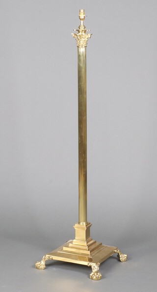 A 19th Century style reeded gilt metal adjustable standard lamp with Corinthian column capital, raised on a square stepped base 132cm h, the base 38cm 