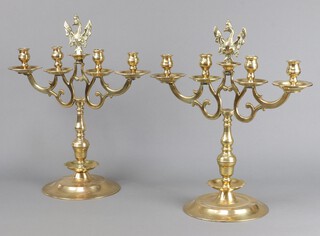 A pair of 18th/19th Century Dutch style brass 4 light candelabrum, each light with drip dray and raised on circular bases, surmounted by a figure of a crowned eagle with wings outstretched and holding swords 49cm h x 42cm w 