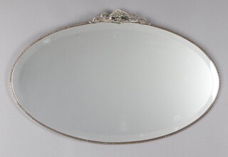 An Art Deco oval bevelled plate wall mirror contained in a silver metal bead work frame surmounted by a shell 44cm x 69cm 