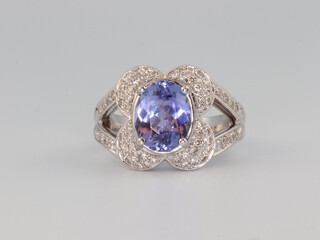 An 18ct white gold tanzanite and diamond dress ring, the centre oval stone 3.1ct, the brilliant cut diamonds 0.5ct, size N 1/2, 8.9 grams 