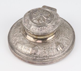 An Indian repousse silver circular capstan inkwell decorated with a village scene 8.5cm 