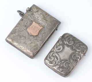 An Edwardian silver vesta with scroll decoration and gold escutcheon, engraved monogram, Birmingham 1904 and a ditto Birmingham 1894, gross weight 44 grams 