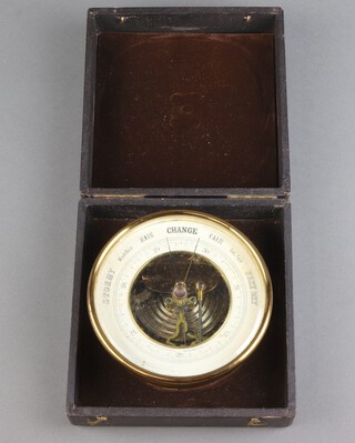 An aneroid barometer, contained in a gilt metal case 30cm diam. and with outer case 