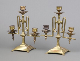 A pair of Victorian aesthetic style 3 light brass candelabrum, raised on square stepped base 23cm x 18cm 