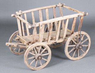 A 19th/20th Century Continental wooden cart with iron shod wheels 63cm h x 84cm w x 57cm d 