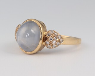 A yellow gold, testing as 18ct, oval cabochon star cut gem set ring with diamond shoulders, the diamonds approx. 0.1ct, the centre stone 2ct, size O, 6.1 grams 