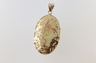 A Chinese white jade oval pendant with 14ct yellow gold mounts, 35mm x 20mm, 7.8 grams