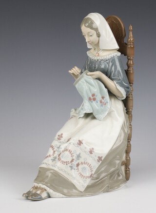 A Lladro figure of a seated sewing lady 30cm 