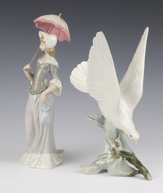 A Lladro figure of a dove standing on a branch 29cm, a ditto of a lady carrying a parasol 32cm 