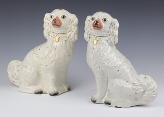 A pair of Victorian white glazed Staffordshire Spaniels with gilt collars 33cm 