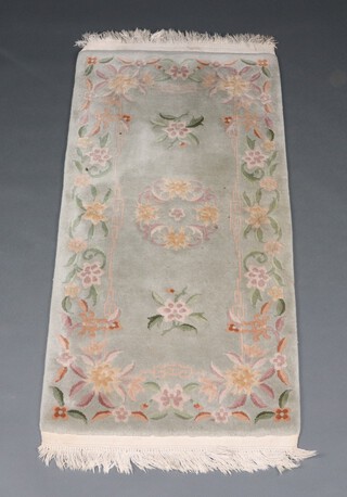 A green and floral patterned Chinese rug 145cm x 69cm 