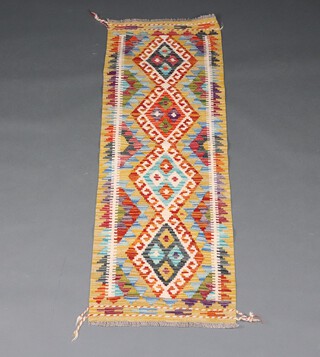 A yellow, green and orange ground Chobi Kilim runner with 3 diamond medallions to the centre 150cm x 52cm 