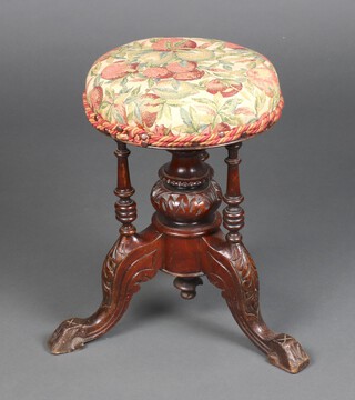 A Victorian carved walnut piano stool raised on bulbous turned column and scroll feet 46cm h x 31cm diam.