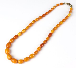 A string of amber, butterscotch coloured beads, the smallest bead 8mm long, the largest 15mm, 24 grams gross weight, 46cm 