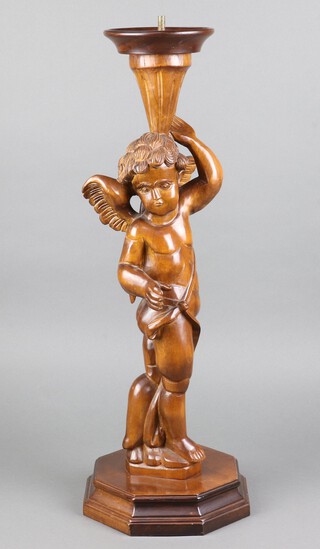 A Continental carved walnut table lamp in the form of a standing cherub with octagonal base 65cm h 