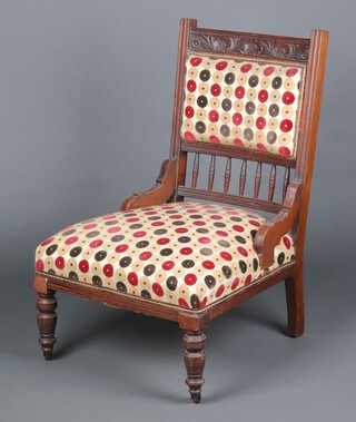 An Edwardian carved walnut nursing chair with bobbin turned decoration on turned supports 90cm x 60cm x 47cm (seat 26cm x 36cm) 